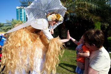 Helter Skelter family and community event gold fairy stilt walker high 5