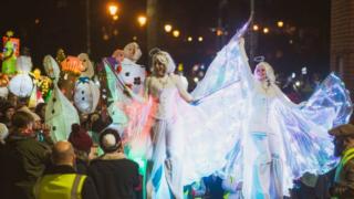 Stilt walkers as angels in parade