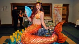 Girl dressed as mermaid living table